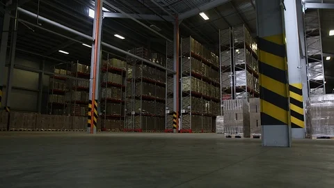 Camera cranes up on shelves of cardboard boxes inside a storage warehouse. Stock Footage 87076131