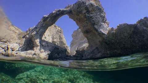Camera crosses the water surface, first shows the coastal rock in the form of an Stock Footage 169238047