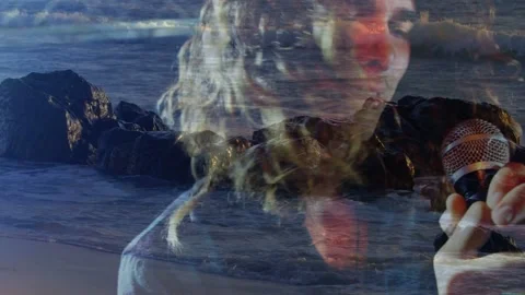Camera cutting closeup lead singer holding mic performing music while ocean Stock Footage 332955927