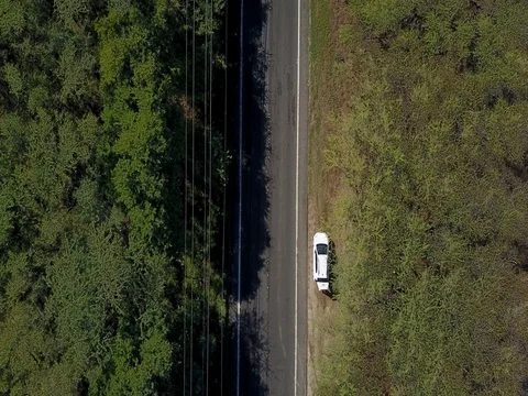 Camera descending down from above onto a drive road with moved rear cars on it Stock Footage 72489907