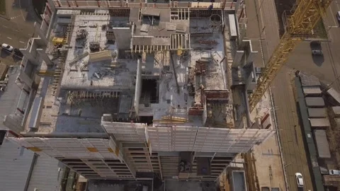 The camera descends on a house under construction with working builders and a Vídeos de archivo 154694119