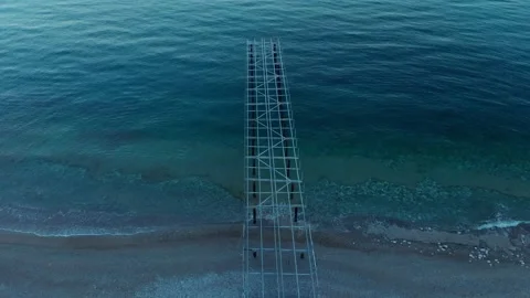 The camera descends over the old frame of the metal sea pier Stock Footage 227580462