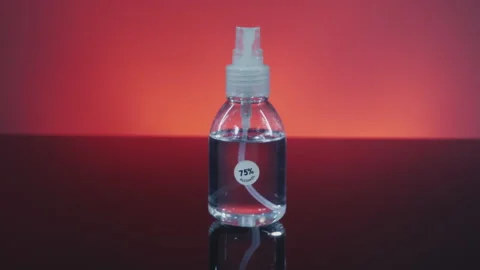 Camera dolly in focus alcohol bottle spray 75 % and change light color Stock Footage 146109944