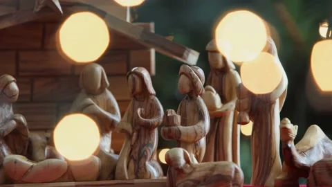 Camera Dolly Left Past Creche Nativity With Hand Putting Baby Jesus Into Mang Video stock 224181409