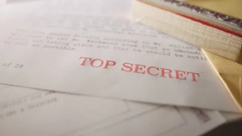 Camera dolly in towards Top Secret red stamp on sensitive classified information Stock Footage 240648526