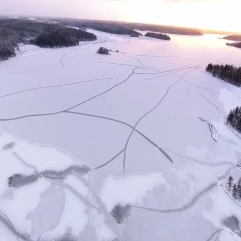 Camera downs above sunset frozen icy lake and winter forests Stock Footage 69489571
