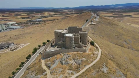 A camera drone ascends over iconic Consuegra Castle and windmills Stock Footage 202072879