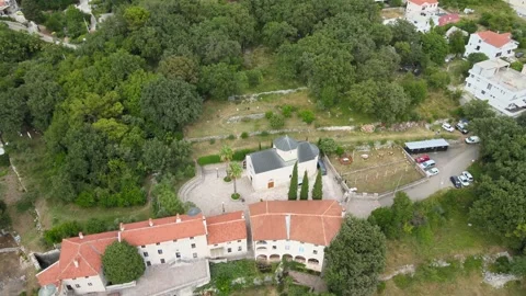 A camera drone flies ahead above Podmaine Monastery, Budva, Montenegro Stock Footage 249418676