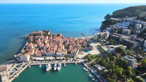A a camera drone flies ahead above Budva Old Town and Dukley Marina Stock Footage 249419106