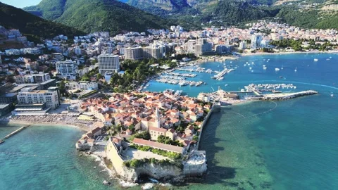 A camera drone flies ahead above Budva Old Town and coastline Stock Footage 249419270