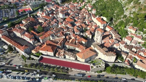A camera drone flies ahead above Kotor Old Town and marina Stock Footage 249421795