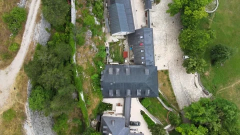 A camera drone flies ahead and above Cetinje Monastery and surrounding mountains Stock Footage 249420714