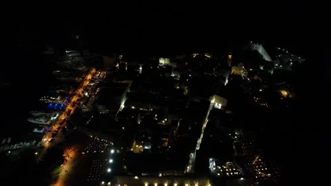 A camera drone flies ahead over Budva Old Town illuminated in the night Stock Footage 249419959