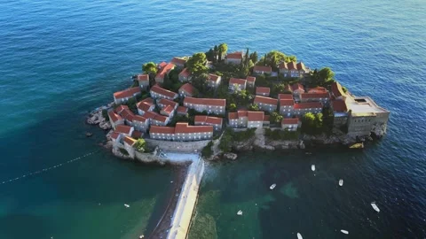 A camera drone flies ahead over St. Stefan Island Stock Footage 249420854