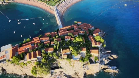 A camera drone flies ahead over St. Stefan Island Stock Footage 249420940