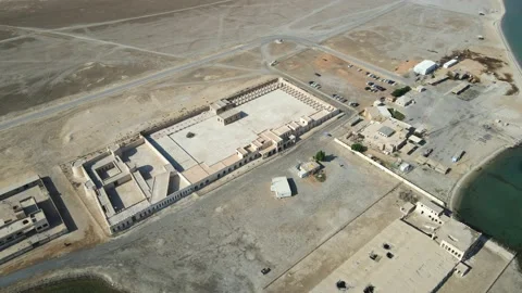 A camera drone flies around Aqeer (Al Uqayr) Castle Stock Footage 220084130