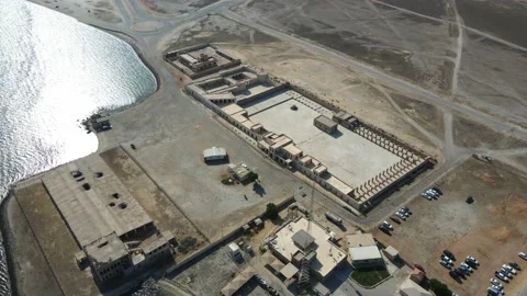 A camera drone flies around Aqeer (Al Uqayr) Castle Stock Footage 220084310