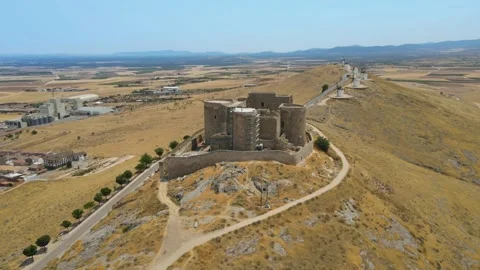 A camera drone flies around over iconic Consuegra Castle and windmills Stock Footage 202072841
