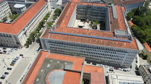 A camera drone flies backward over the University of Coimbra campus Stock Footage 202012226