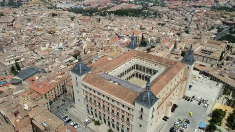 A camera drone flies backward over the old town and the Alcázar of Toledo Stock Footage 202073099