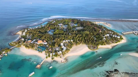 Camera drone flies forward over Kandoomaa Fushi Island with a tourist resort Stock Footage 243528187