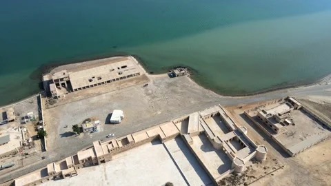 A camera drone flies forward towards the sea over Aqeer (Al Uqayr) Castle Stock Footage 220084810