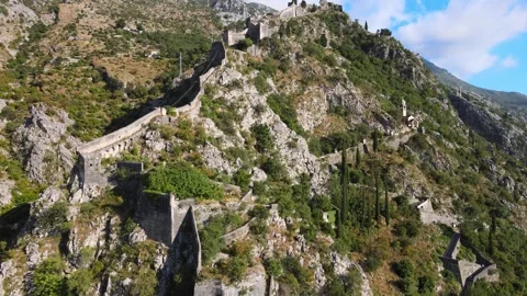 A camera drone flies toward the ancient walls of Kotor Old Town Stock Footage 249421831