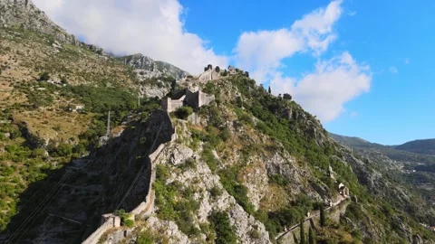 A camera drone flies toward the ancient walls of Kotor Old Town Stock Footage 249421869