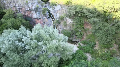 A camera drone flies toward Čučuci Waterfall near Becici, Montenegro Stock Footage 249419688