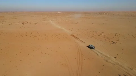 Camera drone flying over a racing truck running in the desert Stock Footage 169274678