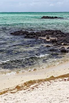 Camera drone hovering over a rocky volcanic shoreline and turquoise sea at .. Stock Photos