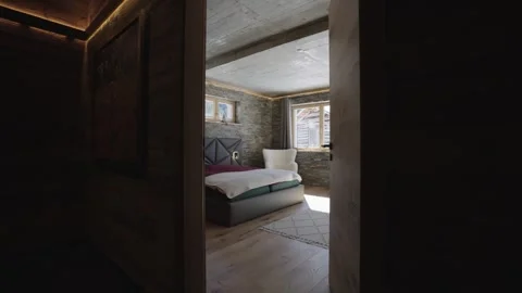 Camera entering a rustic luxury bedroom with stone walls and a scenic mountain 스톡 동영상 335757158