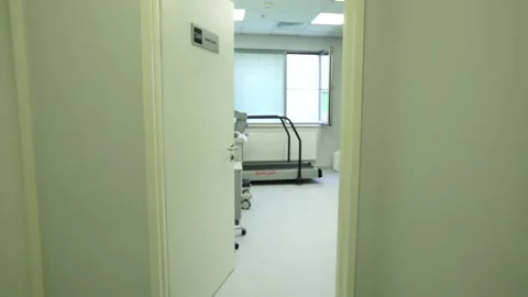 The camera enters the room where the treadmill is installed in the hospital Video stock 130648663