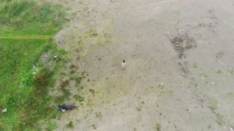 The camera facing down follows the drone controller in the field Stock Footage 238591184