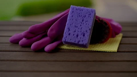 Camera finds a rag, sponge, brush, gloves putting on the wooden table. Close up. Stock Footage 92234956