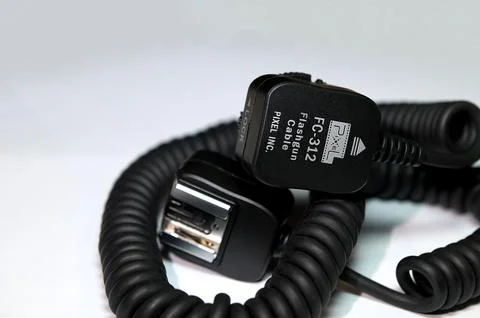 Camera flash sync cable on blue background Stock Photos