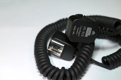 Camera flash sync cable on blue background Stock Photos