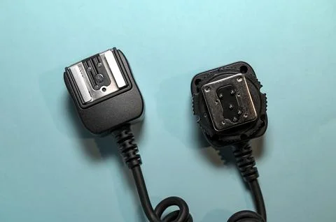 Camera flash sync cable on blue background Stock Photos