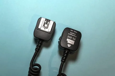 Camera flash sync cable on blue background Stock Photos