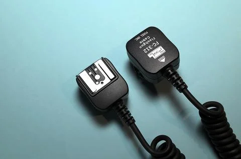 Camera flash sync cable on blue background Stock Photos