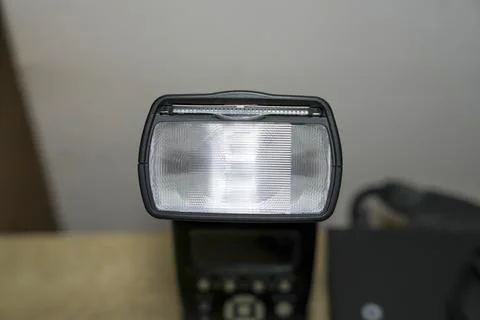 Camera flash unit displayed against a neutral background, representing essential Foto stock