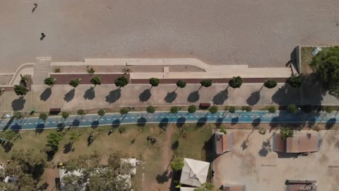 The camera flies along the beach over a well-equipped blue jogging track. Stock Footage 220421114