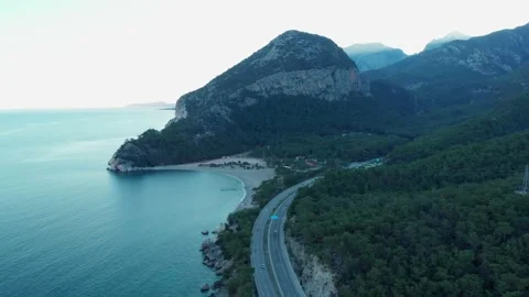 The camera flies along the coast, over the road on which cars are traveling Stock Footage 227574255