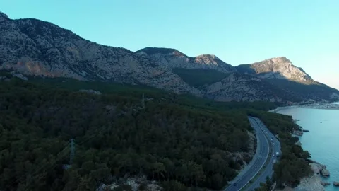 The camera flies along the coast, over the road on which cars are traveling Video stock 227708992