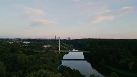 The camera flies along the river to the pedestrian bridge. Drone flying over the Video stock 251748947