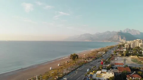 The camera flies along the sea beach in the southern city near the mountains Stock Footage 222603142
