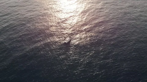Camera flies around a lonely boat in the clear sea Stock Footage 101485173