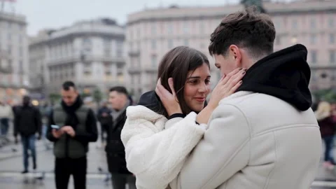 The camera flies around a romantic couple standing in the main square of Milan Stock Footage 258748505
