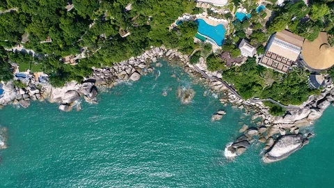 The camera flies around the small round tropical island resort hotel Stock Footage 94721683