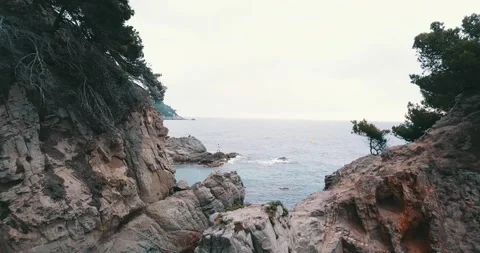 The camera flies between two rocks towards a fisherman Stock Footage 147056861